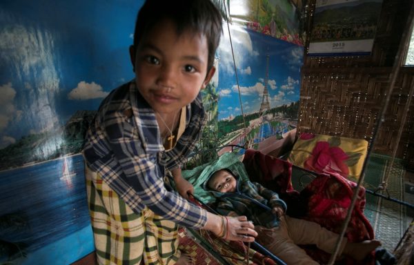 Un bimbo si prende cura del suo fratellino in Myanmar. Foto di Gianfranco Ferraro.